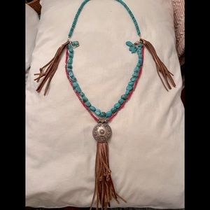 Western style necklace with silver tone pendant, leather tassels, turquoise